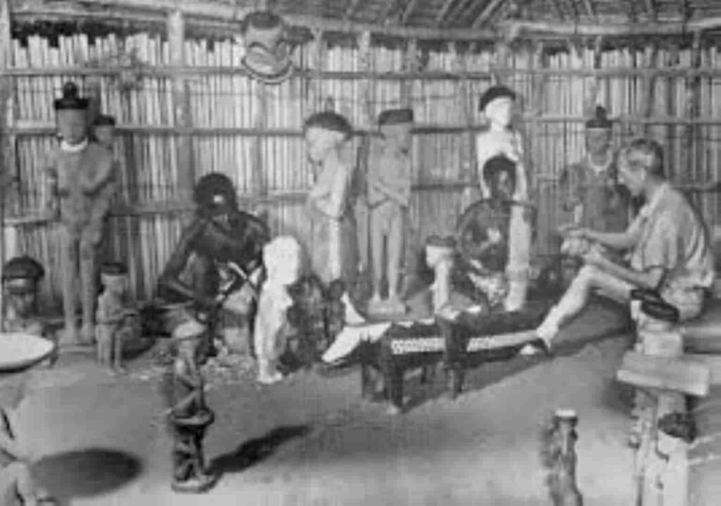 Aunque este ejemplo fotográfico no sea el caso, o sí, es una buena muestra del interés ‘occidental’, reitero lo de que parece que ellos no lo tienen, por los trabajos artesanos, cómo vemos, en que  bajo la mirada de un interesado ‘occidental’, se tallan máscaras y figuras en lo que prodríamos llamar un taller pende.
Desconozco todo lo relativo a esta foto, ni datos del autor ni de quienes son los retratados, ni la fecha.
